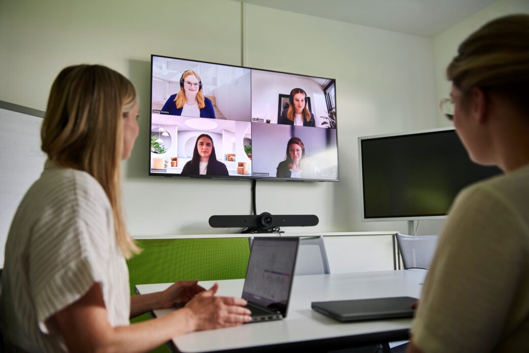 Mitarbeitende nehmen an einer hybriden Videokonferenz teil