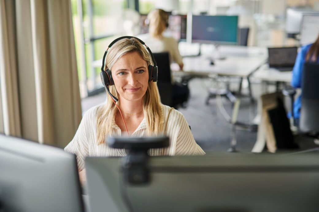 Mitarbeiterin sitzt im Büro und nimmt an einer Videokonferenz teil